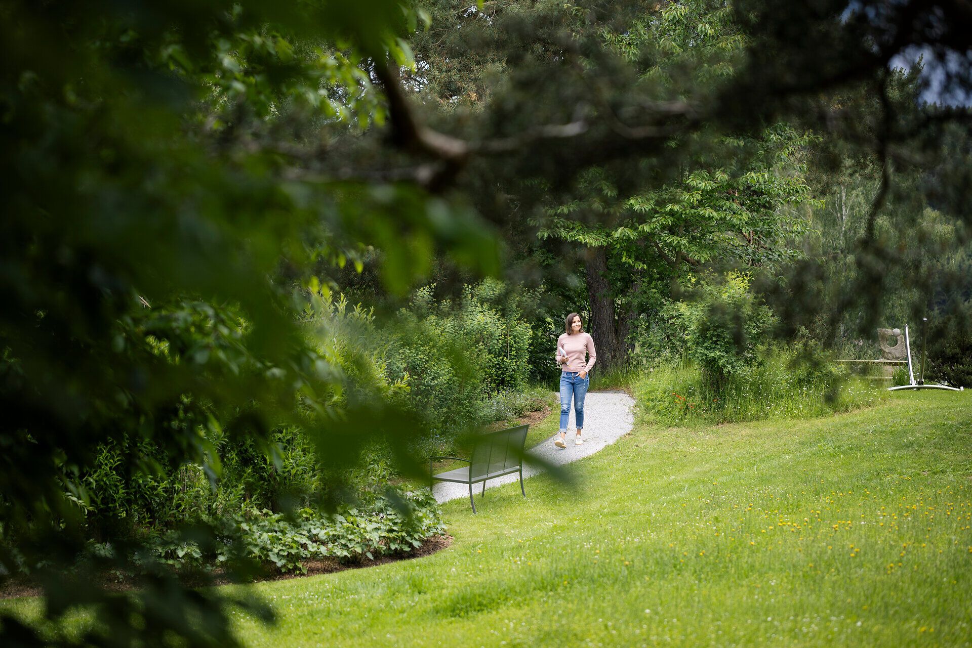 Eine Frau spaziert durch den Garten des Gesundheitshotels Klosterberg im Waldviertel.