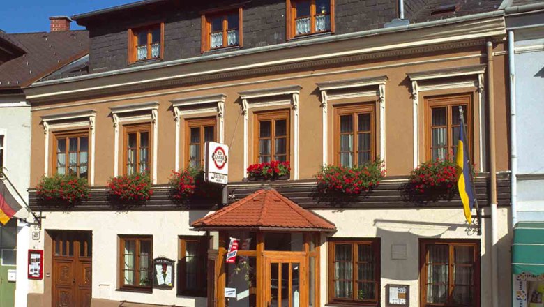 Traditionelles Gasthaus mit Blumen und Fahnen.