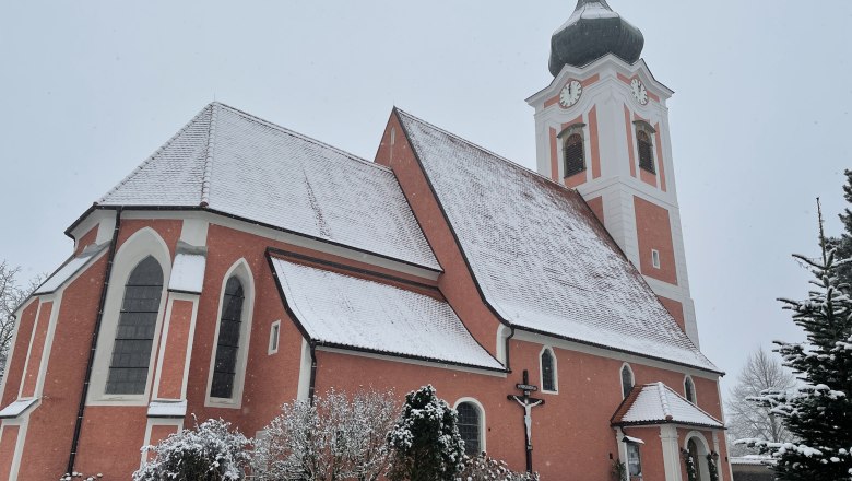 Pfarrkirche Gottsdorf im Winter mit schneebedecktem Dach und Turm.