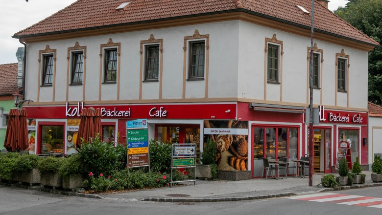 Ein zweist&ouml;ckiges Geb&auml;ude mit einem Caf&eacute; und B&auml;ckerei im Erdgeschoss in Pitten.