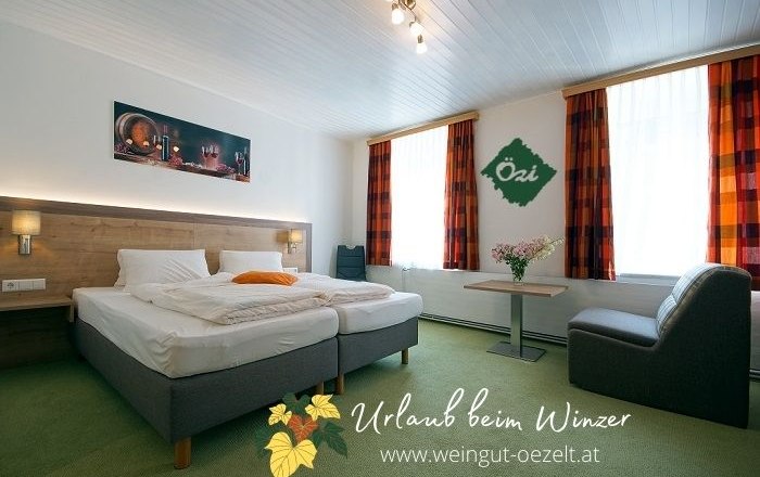 Gemütliches Gästezimmer mit Doppelbett, Tisch, Stuhl und dekorativen Elementen an den Wänden.