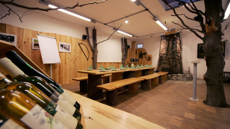 Gemütliches Naturparkhaus mit Holztisch, einem Baum im Zimmer und warmem Holzinterieur.