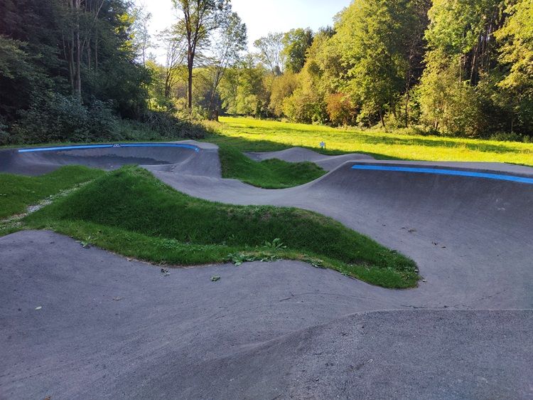 Pumptrack in Bad Schönau mit grüner Umgebung und Bäumen im Hintergrund.