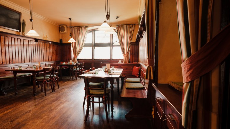 Gem&uuml;tliches Restaurant mit Holzm&ouml;beln und warmem Licht.