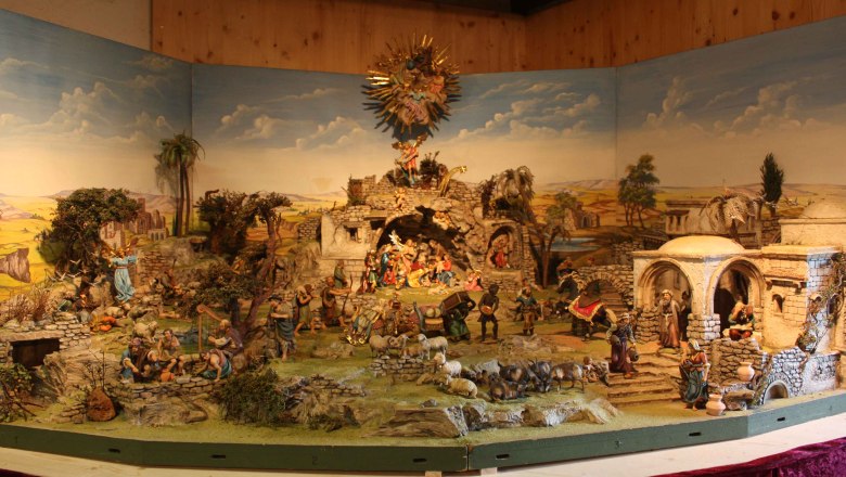 Alpenl&auml;ndische Krippe mit Figuren und Landschaft.