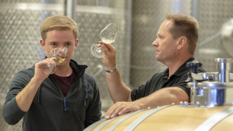 Zwei M&auml;nner verkosten Wein in einem Weinkeller.