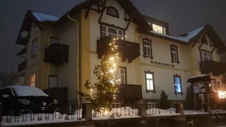 Ein beleuchtetes Geb&auml;ude im Schnee mit Weihnachtsdekoration.