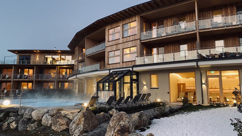 Hotelgeb&auml;ude mit Au&szlig;enpool und Schnee im Vordergrund.