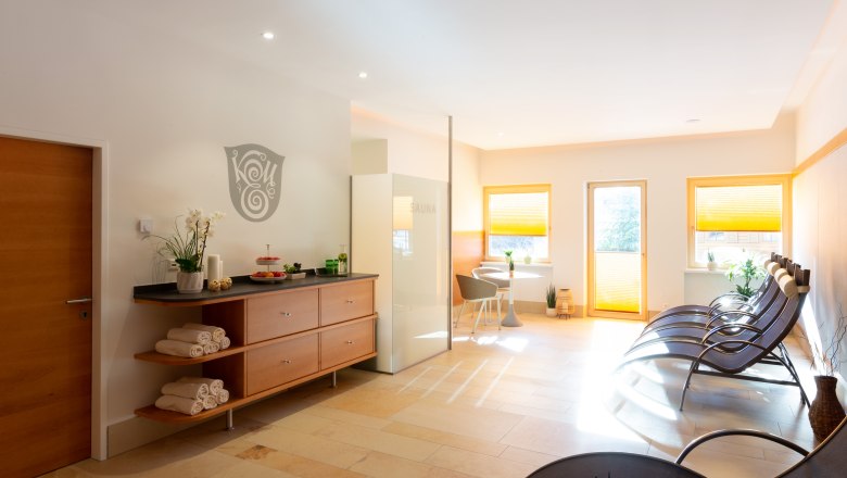 Moderner Wellnessbereich mit Liegestühlen, Sauna und Dekoration.