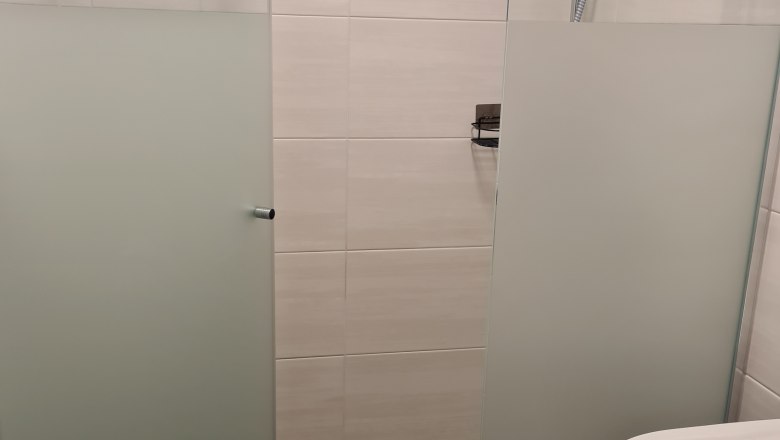 Moderne Dusche mit Glasw&auml;nden und Duschkopf in einem Badezimmer.