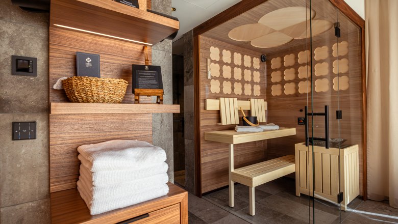 Innenansicht einer modernen Sauna mit Holzverkleidung und Glasfront.