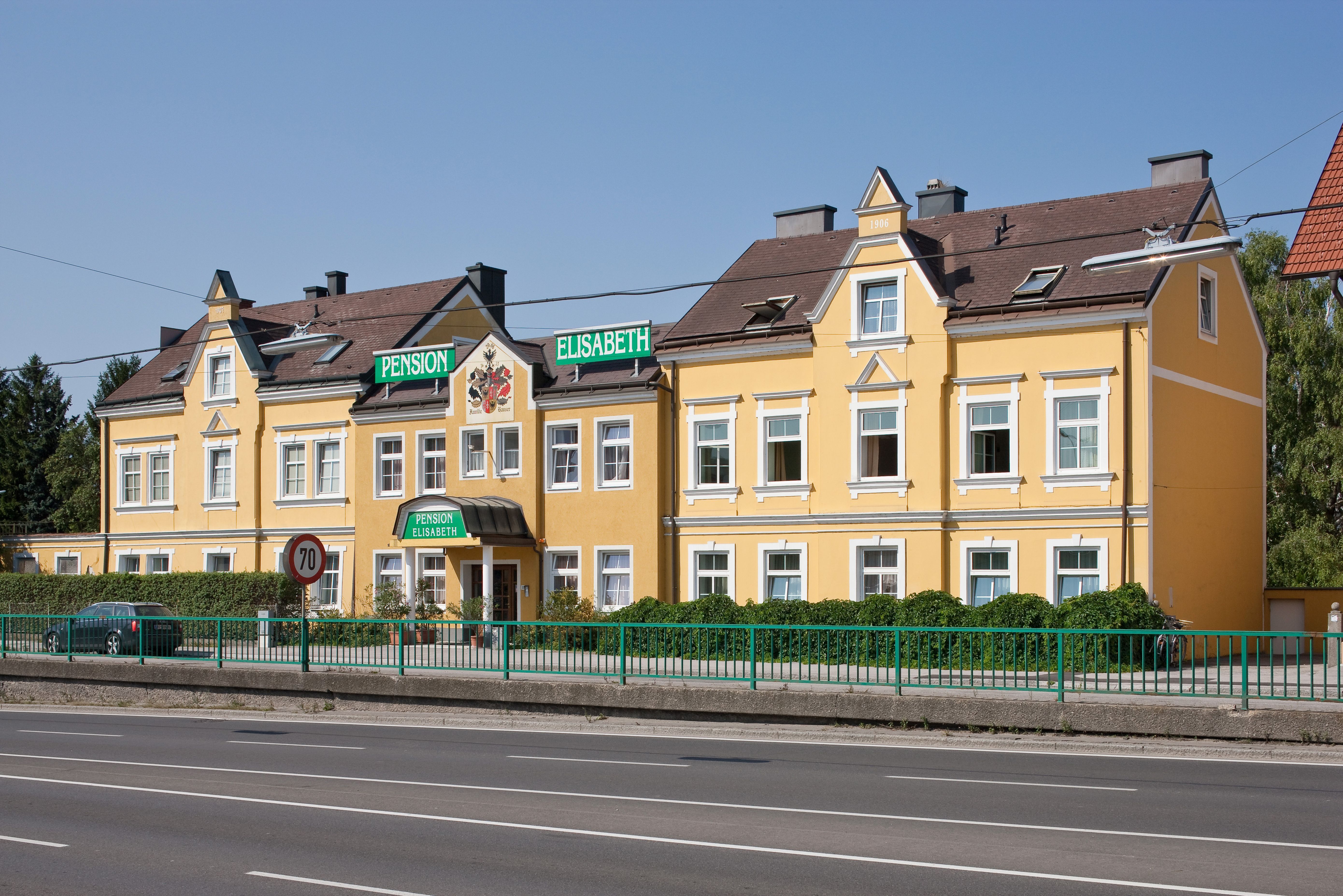 Gelbes Gebäude der Pension Elisabeth mit grünen Schildern.