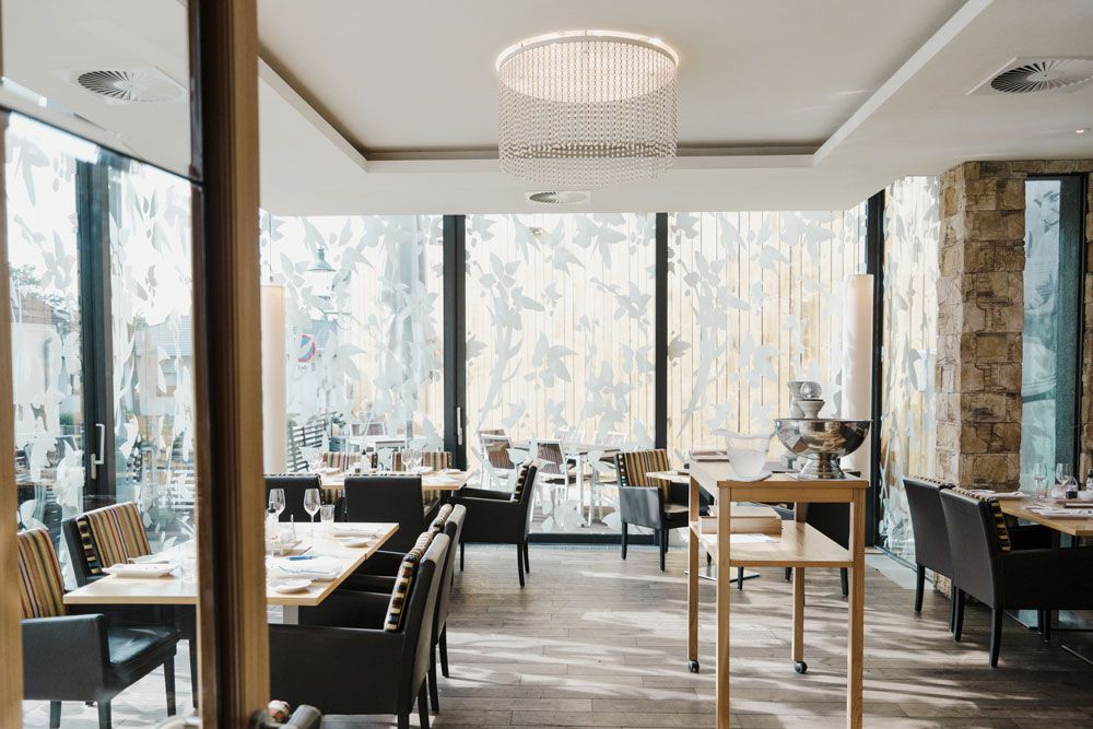 Modernes Restaurant mit großen Fenstern und eleganter Einrichtung.