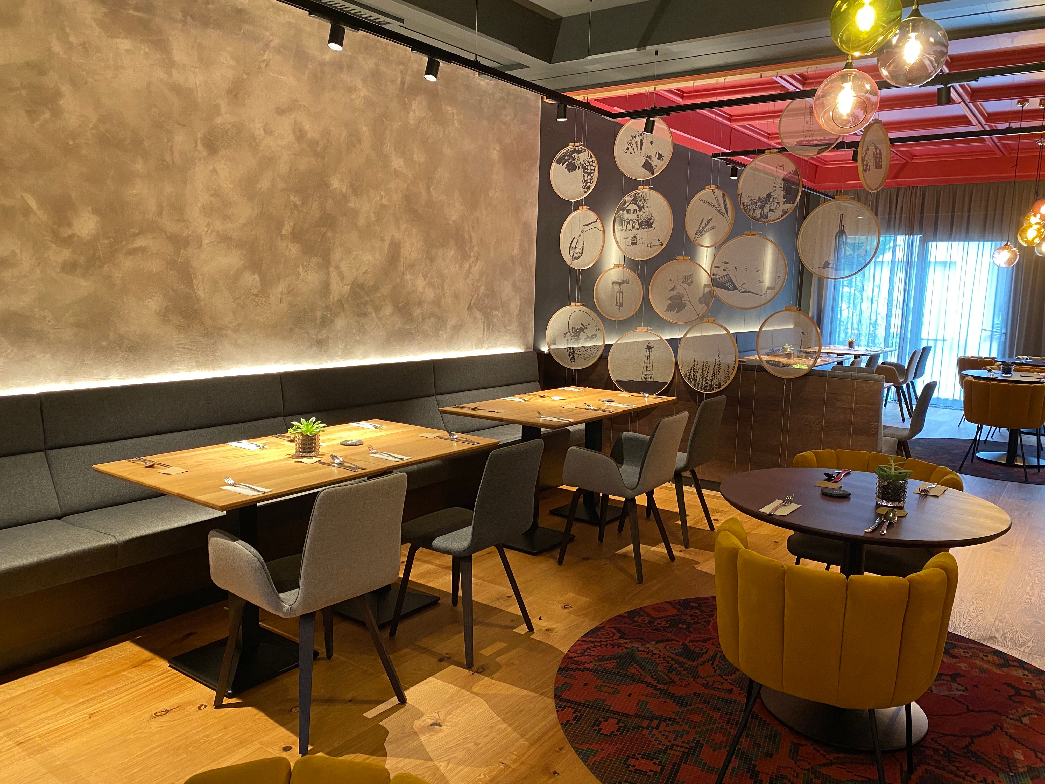 Modernes Restaurant mit stilvoller Einrichtung und dekorativen Elementen an der Wand.