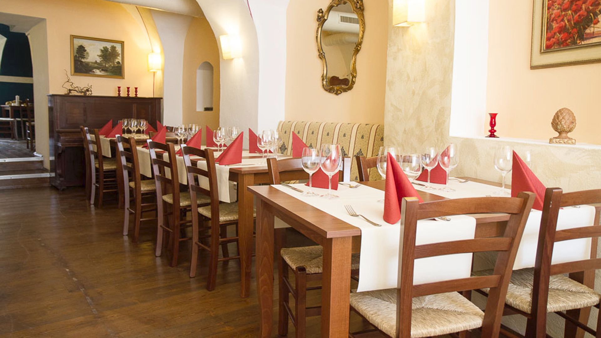 Elegantes Restaurant mit gedeckten Tischen und roten Servietten.
