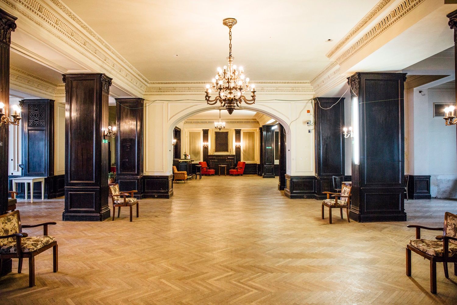 Eleganter Raum mit Kronleuchtern und Holzmöbeln im Südbahnhotel Café.