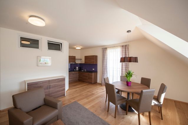 Modernes Wohnzimmer mit Holzboden, Esstisch und Küchenzeile.