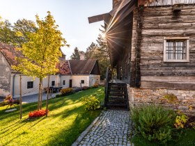 Traditionelle Geb&auml;ude und Gr&uuml;nanlage im Museumsdorf Krumbach bei Sonnenuntergang.