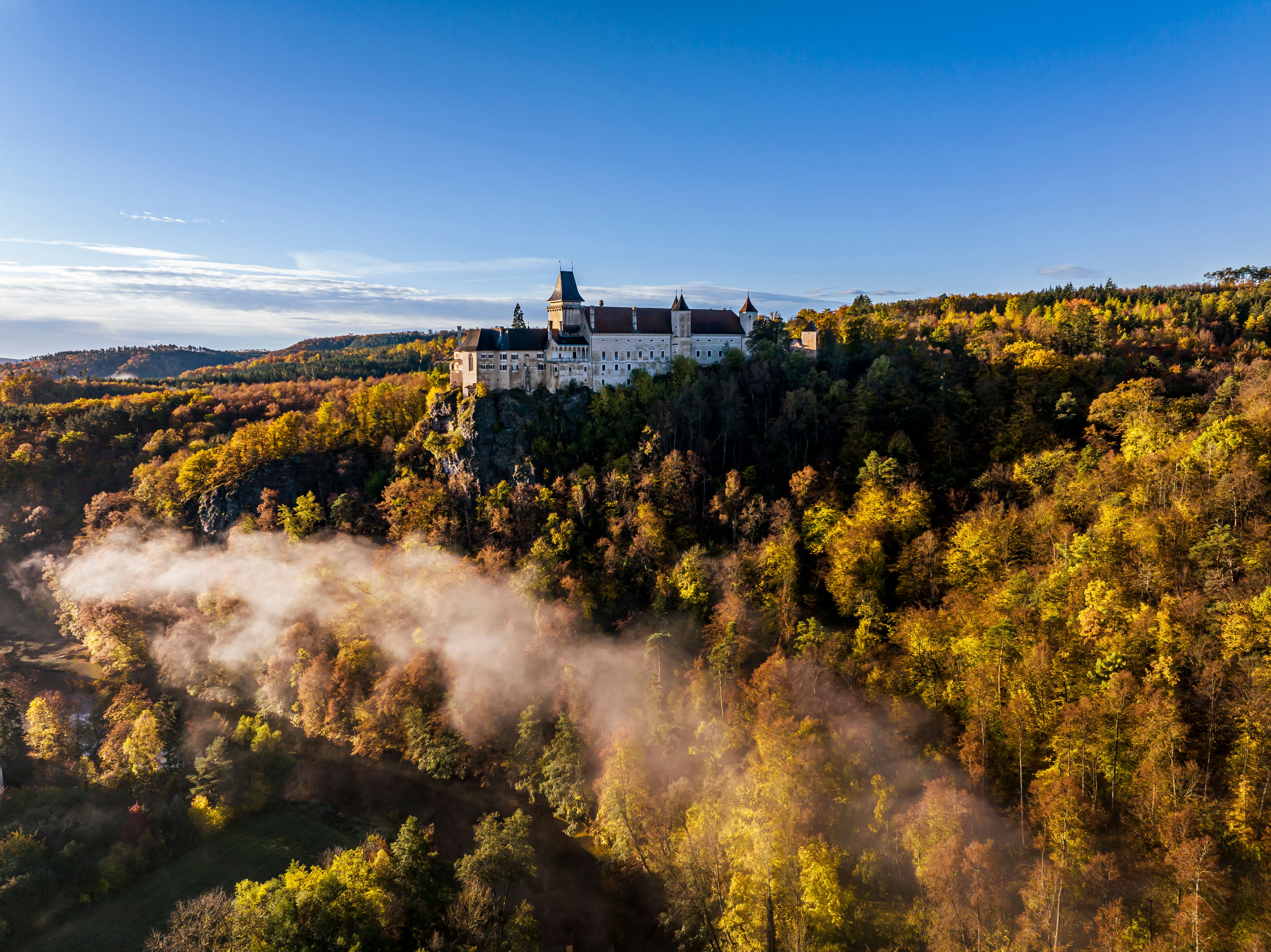 Luftaufnahme der Rosenburg inmitten grüner Wälder und Hügel.