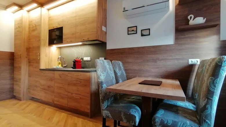 Moderne Küche mit Holzmöbeln und Esstisch in einem Apartment.