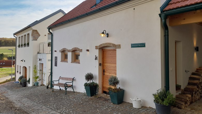 Ein renoviertes Geb&auml;ude mit roten Ziegeld&auml;chern und wei&szlig;er Fassade auf einem Biohof.