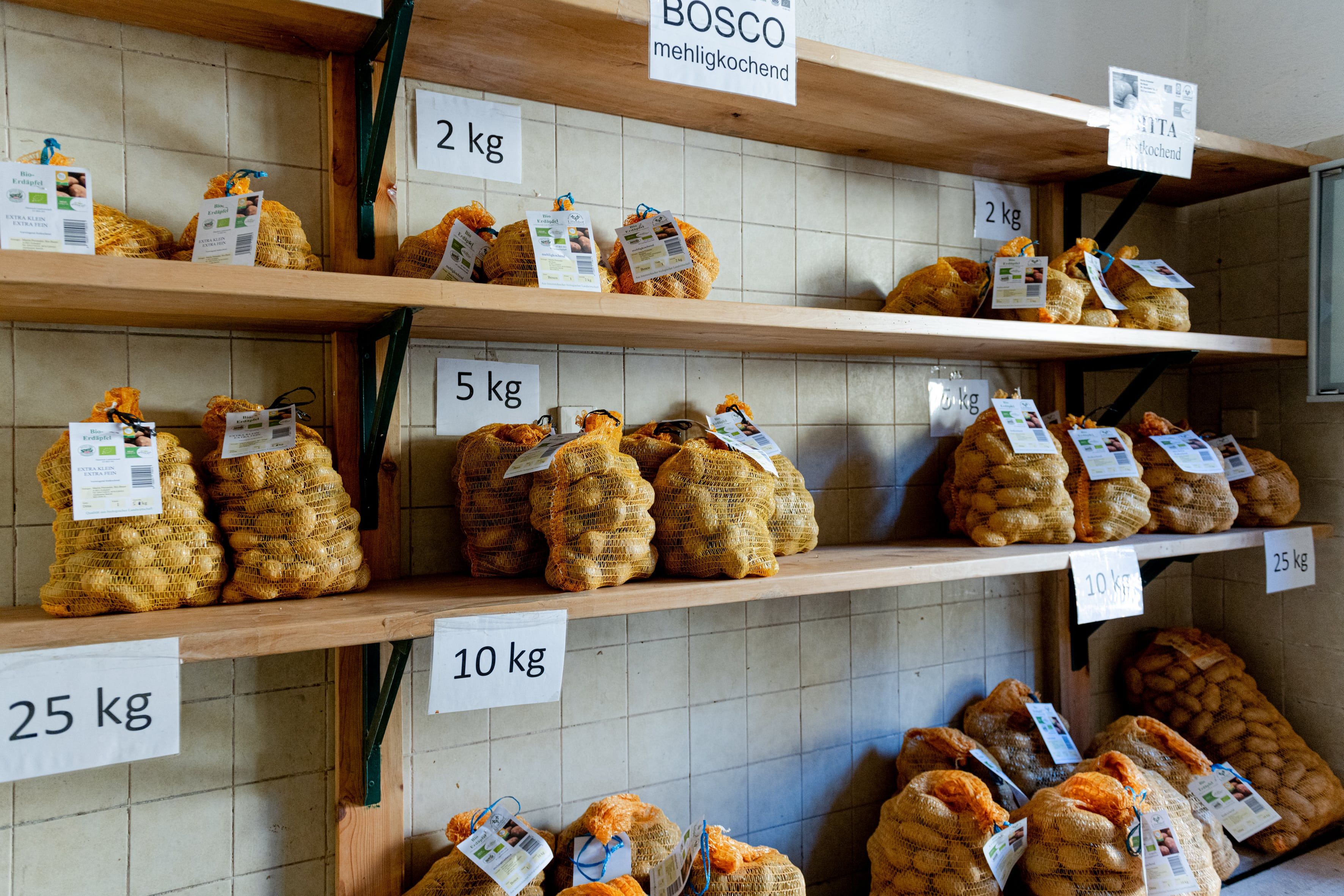 Verkaufsraum mit Regalen mit Kartoffelsäcken in verschiedenen Gewichtseinheiten.