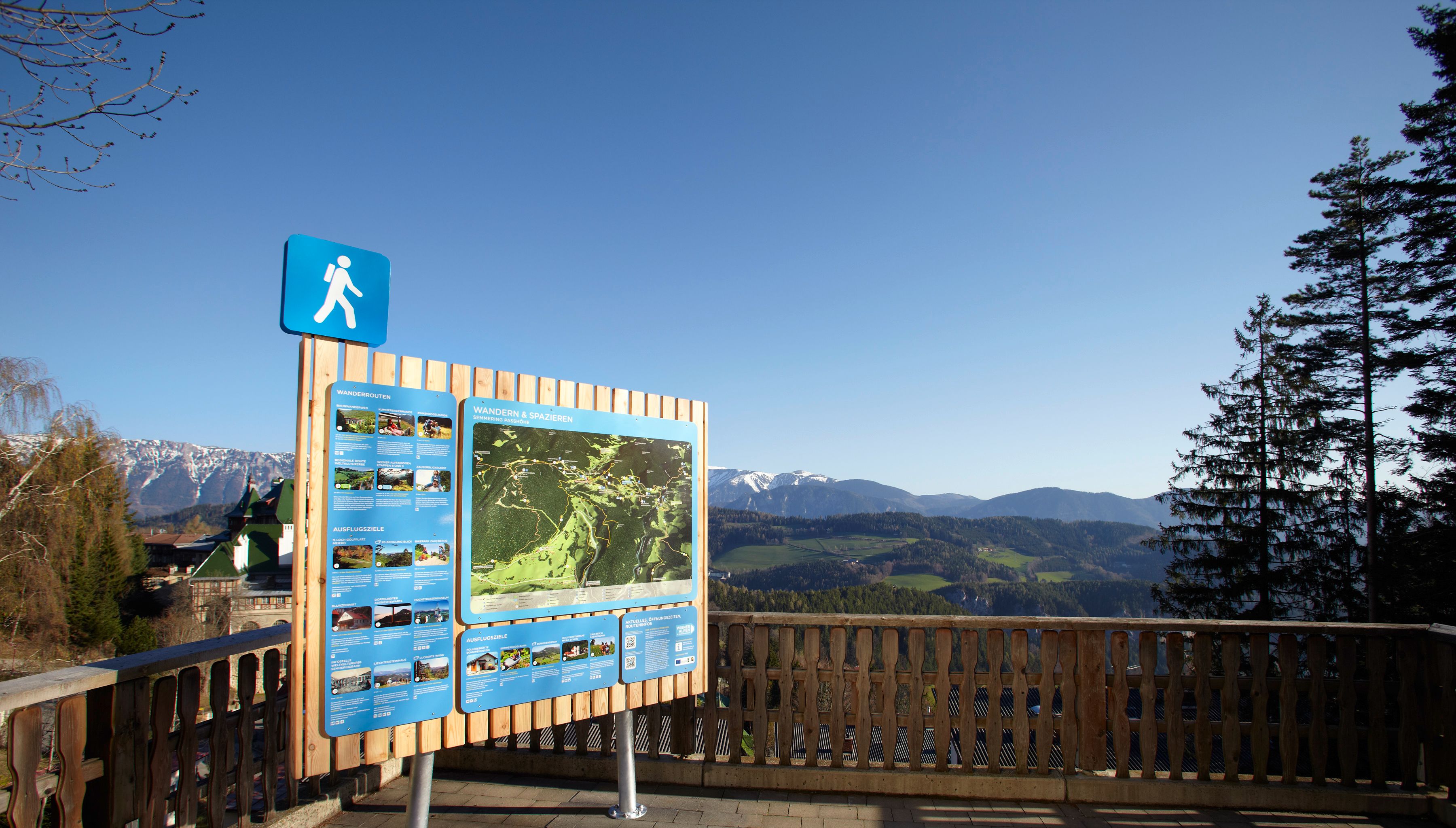 Wanderstartplatz Semmering mit Infotafel und Berglandschaft im Hintergrund.