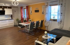 Moderne Wohnküche mit Esstisch, Stühlen, Sofa und Küchenzeile.