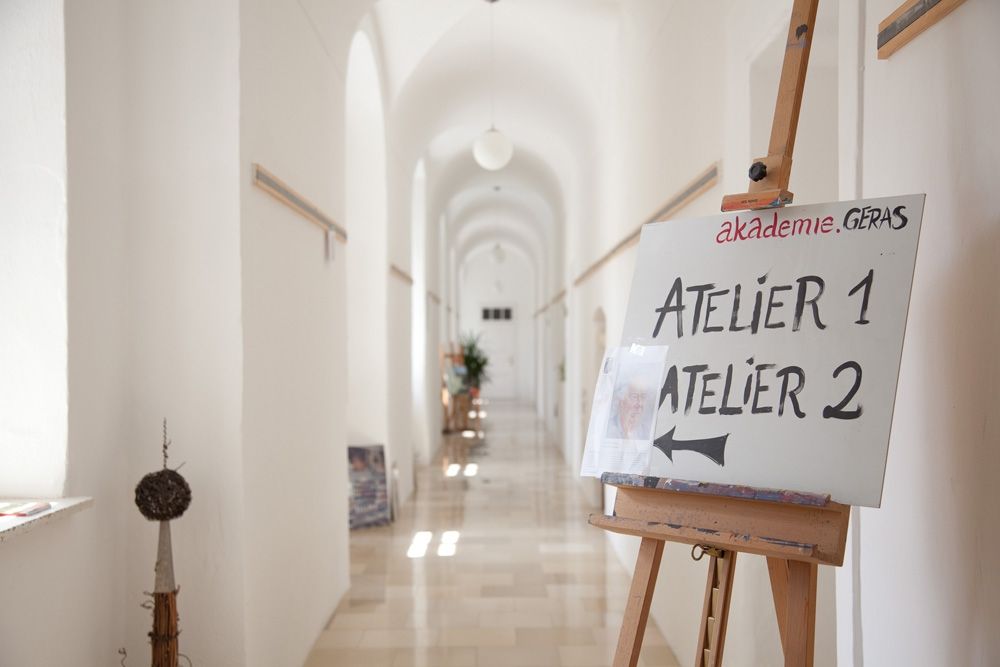 Ein heller Flur mit einem Schild auf einer Staffelei, das auf Atelier 1 und Atelier 2 hinweist.