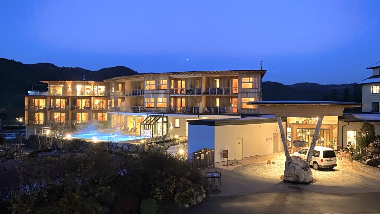 Hotel Molzbachhof bei Nacht mit beleuchteten Fenstern und Pool.