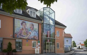 Außenansicht des Oskar Kokoschka Hauses mit großem Gemälde an der Fassade.