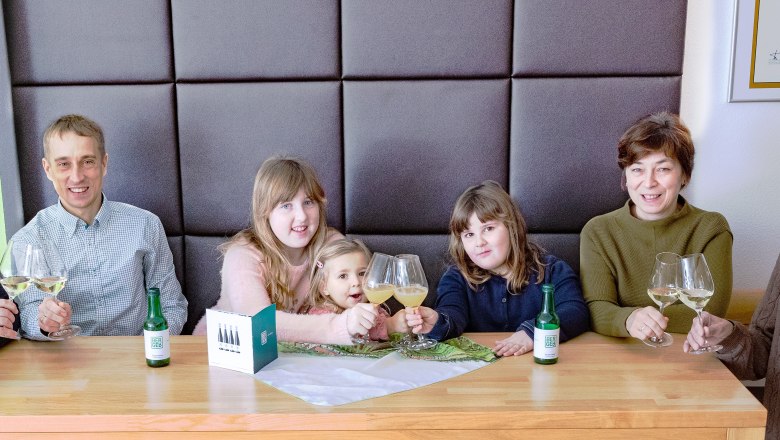 Gruppe von Menschen sitzt an einem Tisch mit Weingl&auml;sern in einem Verkostungsraum.