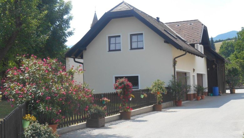 Ferienwohnung am Bauernhof mit Blumen und Bäumen.