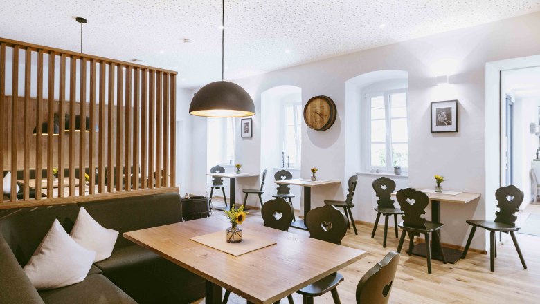 Moderne Gaststube mit Holzm&ouml;beln und stilvoller Beleuchtung.