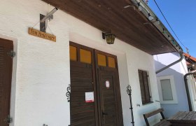 Eingang eines Heurigenlokals mit Holzschild 'Fam. Keiblinger'.