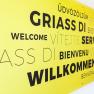 Ein Schild mit dem Wort Willkommen in verschiedensten Sprachen.
