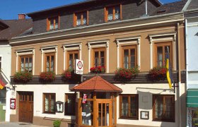 Traditionelles Gasthaus mit Blumen und Fahnen.