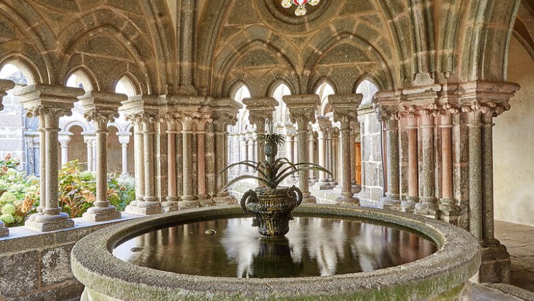Ein Brunnen im Kreuzgang des Stifts Zwettl mit verzierten S&auml;ulen und einem gotischen Gew&ouml;lbe.