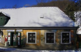 Ein verschneites Gebäude mit bemalter Fassade und der Aufschrift 'Restaurant Kaiserziegel'.