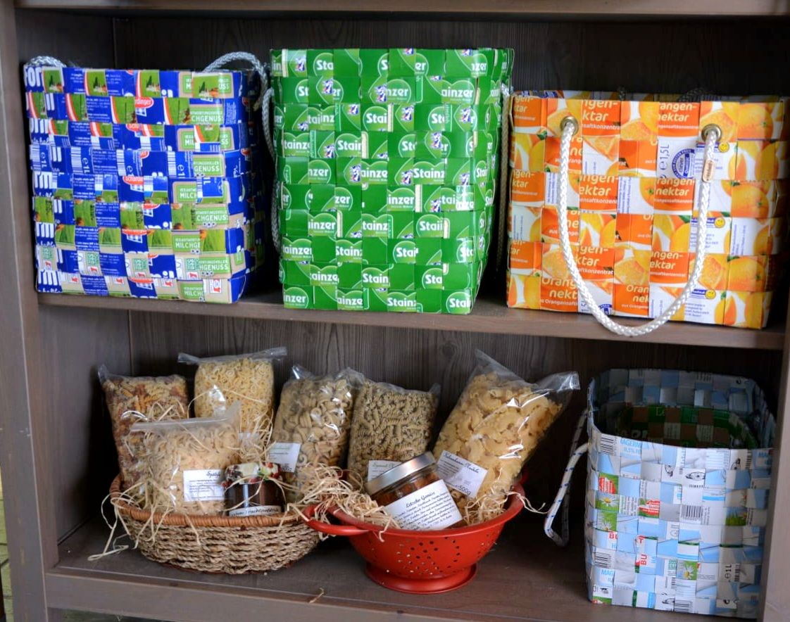 Regal mit geflochtenen Körben aus Verpackungen.