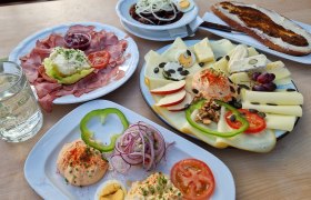 Verschiedene österreichische Heurigenjause-Gerichte auf einem Tisch.