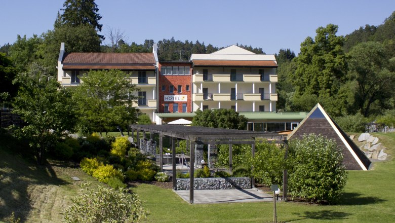 Außenansicht eines Hotels mit Garten und Pavillon.