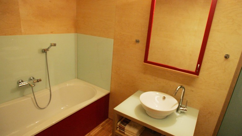 Modernes Badezimmer mit Badewanne, Waschbecken und Spiegel.