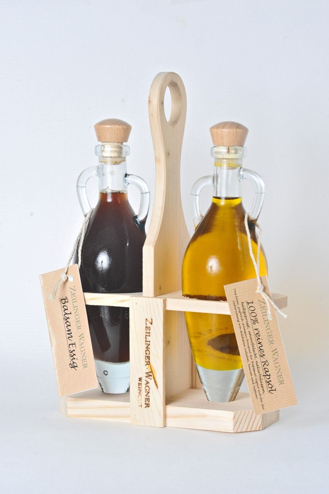 Zwei Glasflaschen mit Essig und Öl in einem Holzständer.