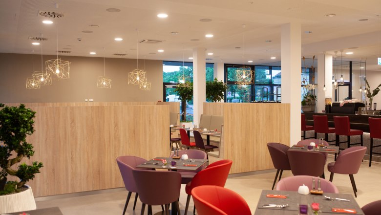 Bunte Möbel stehen in einer hellen Hotellounge