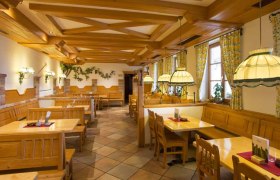 Innenansicht eines traditionellen Heurigenlokals mit Holzm&ouml;beln und gem&uuml;tlicher Beleuchtung.