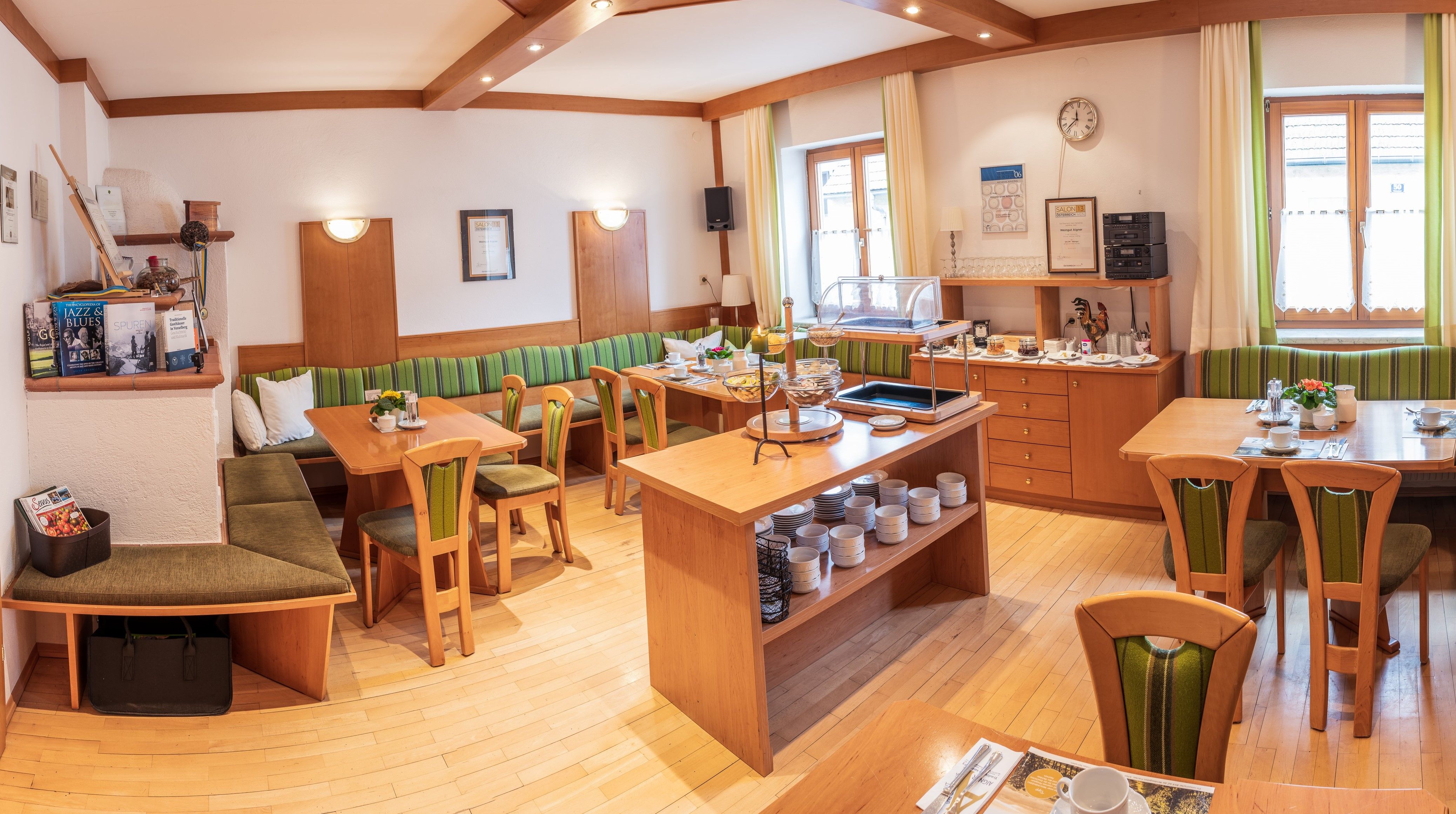 Ein gemütlicher Frühstücksraum mit Holzmöbeln, gedeckten Tischen und einem Buffet.