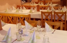 Eingedeckte Tische innen mit wei&szlig;er Tischw&auml;sche