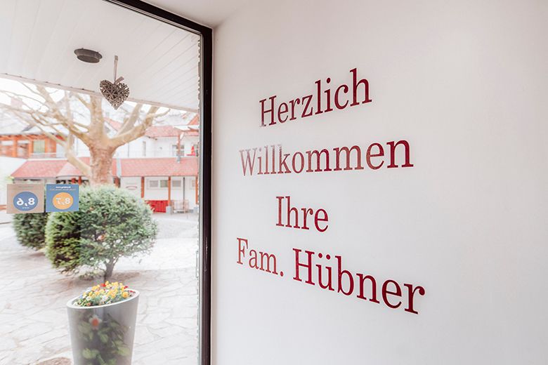 Eingangsbereich mit Begrüßungstext an der Wand und Blick nach draußen.