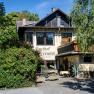 Gasthof Scherrerwirt mit Terrasse und grüner Umgebung.